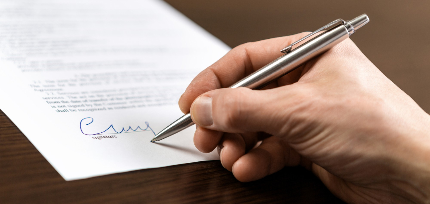 Hands reviewing and signing official translated documents